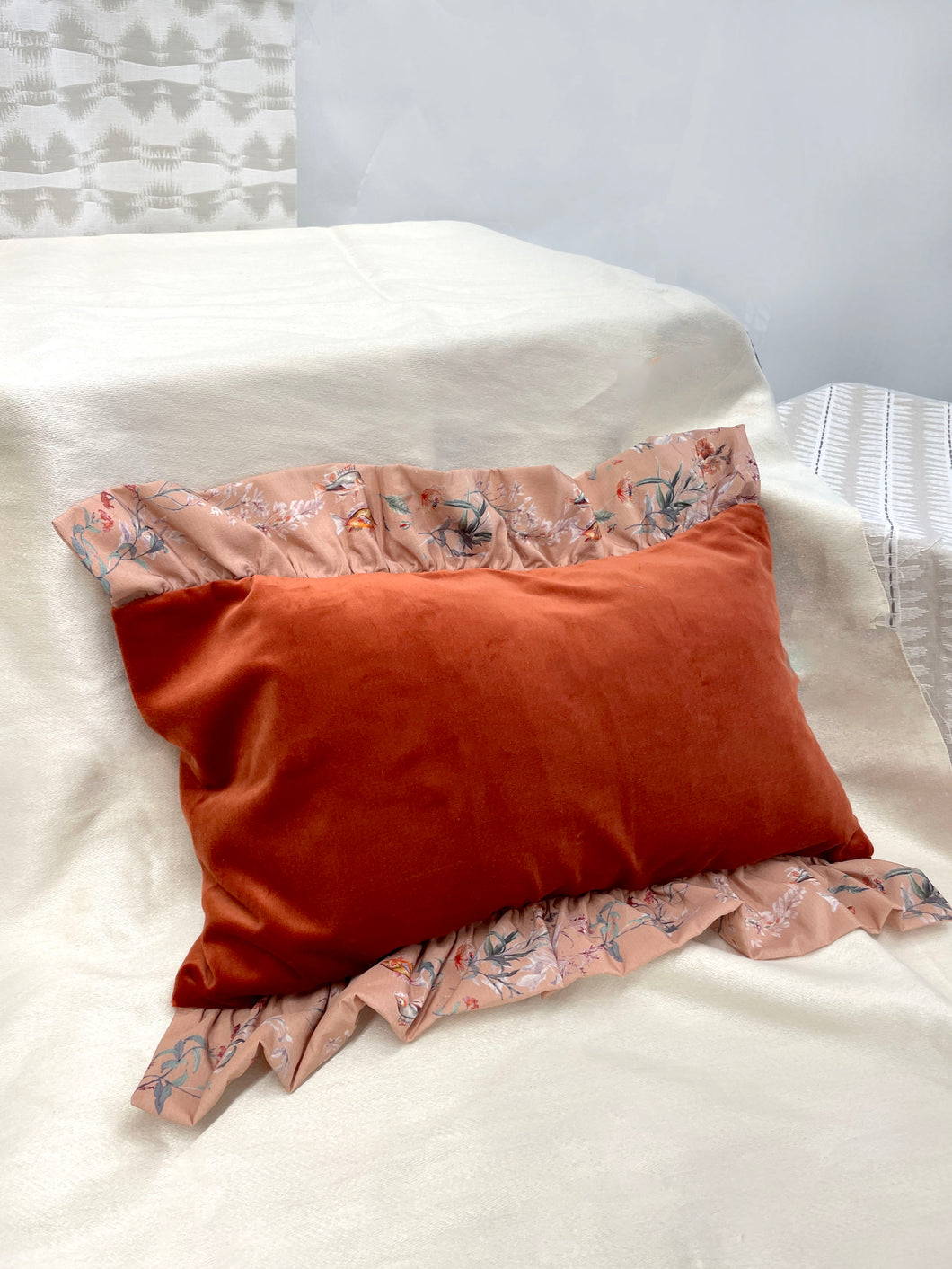 Rust colour velvet rectangular cushion with 'Mirage' print silk frill trim